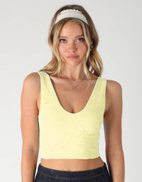 Woman wearing a light yellow tank top with text '2253 PALE BANANA' on a white background