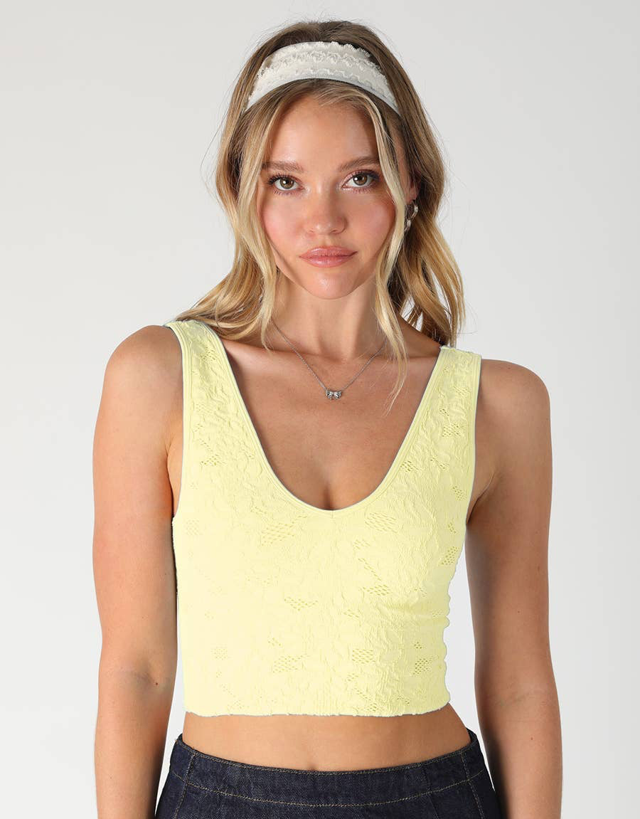 Woman wearing a light yellow tank top with text '2253 PALE BANANA' on a white background