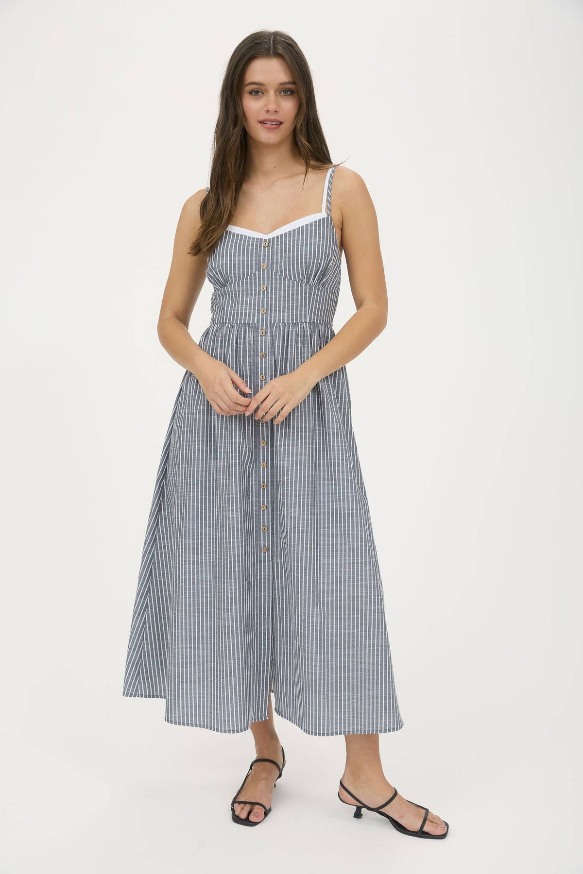 Woman wearing a blue and white striped dress on a white background