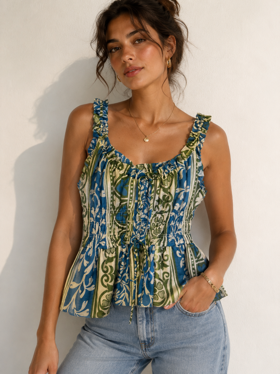 Woman wearing a patterned sleeveless top against a plain background
