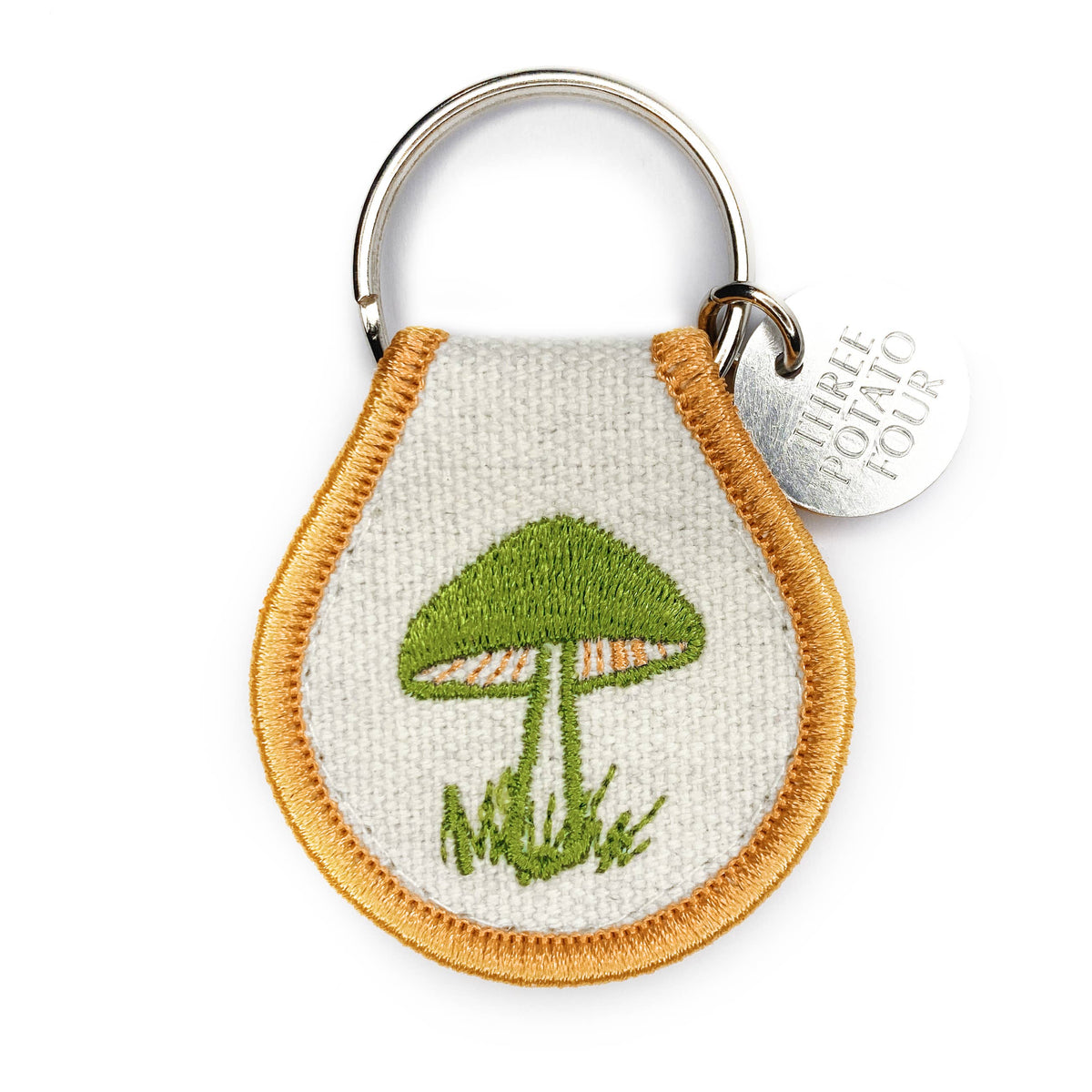Keychain with embroidered green mushroom design on a white background