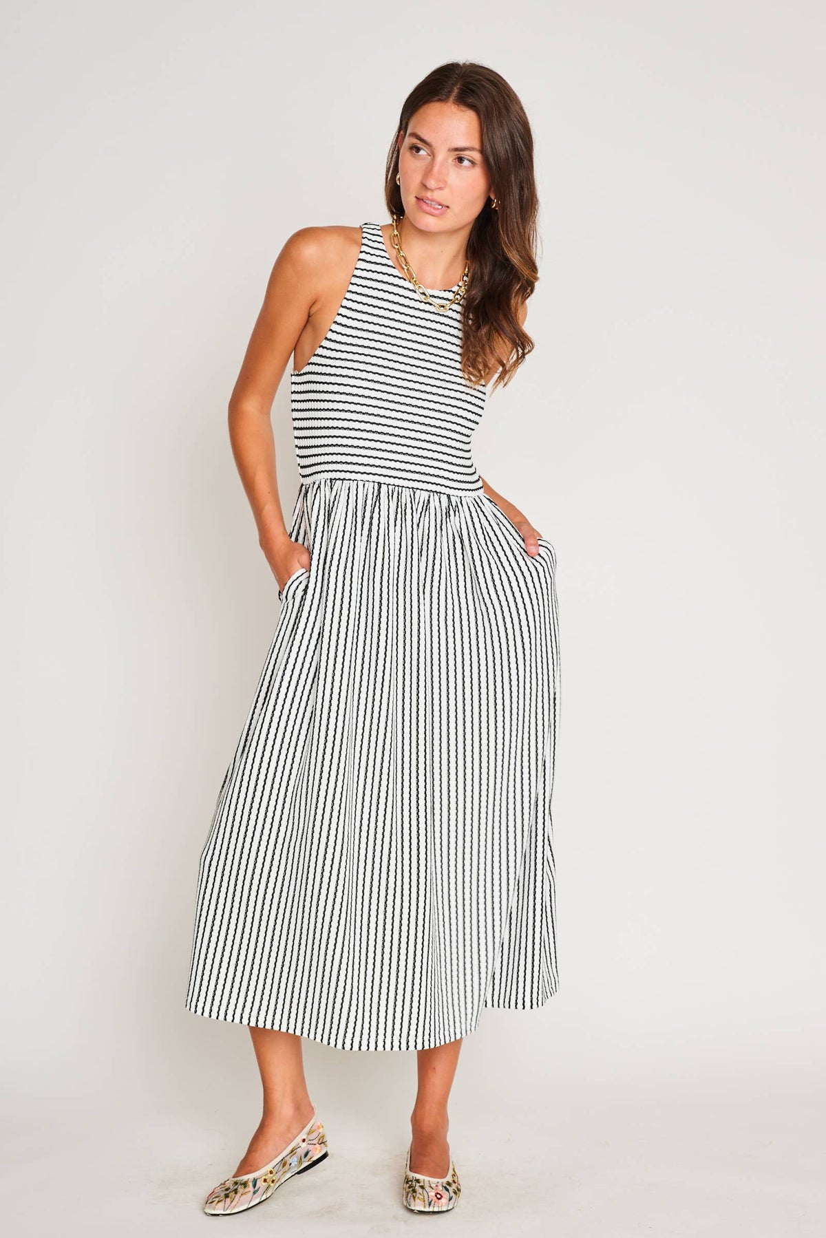 Woman wearing a black and white striped dress against a plain background