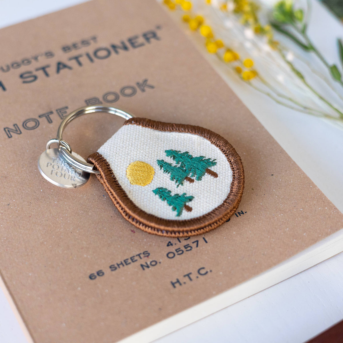 Embroidered keychain with nature design on a notebook