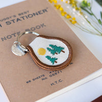 Embroidered keychain with nature design on a notebook